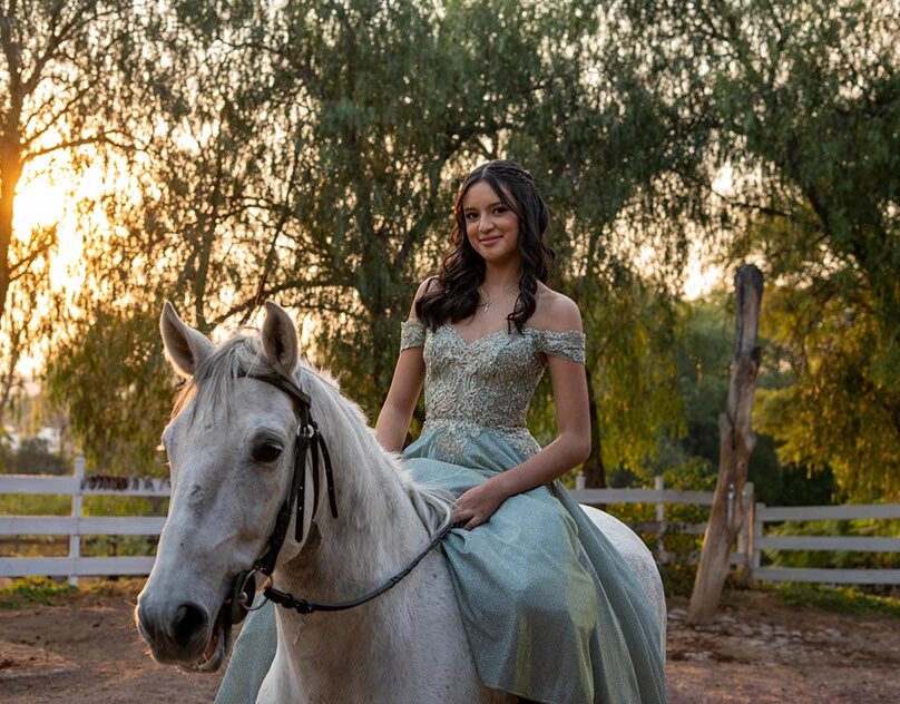 Retrato de quinceañera a caballo durante una sesión al atardecer